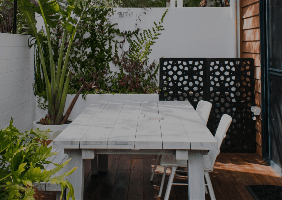 A-white-wooden-table-and-chairs-in-a-geometric-patterned-wall